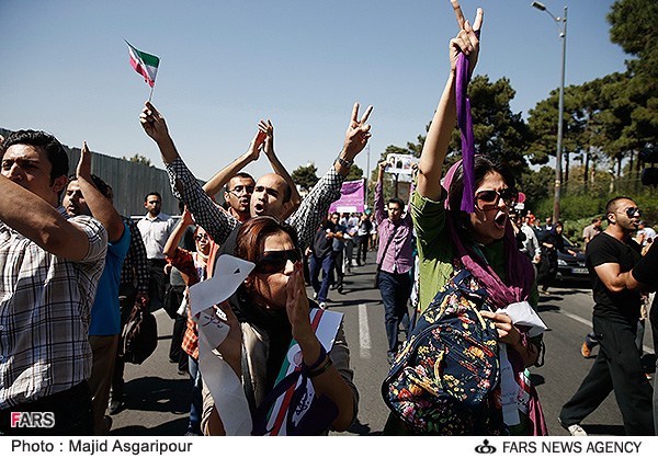 Iranians cheer, also protest over Rouhani