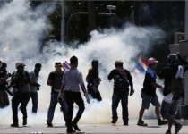 Thai riot police fire teargas to disperse protesters attacking Gov