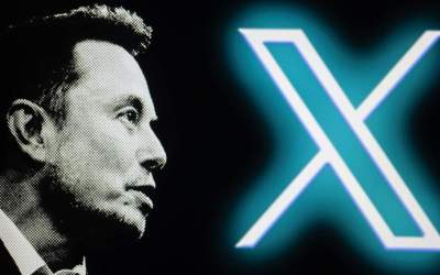 The new Twitter logo, rebranded as X, is being displayed on a screen alongside Elon Musk ©  Jonathan Raa