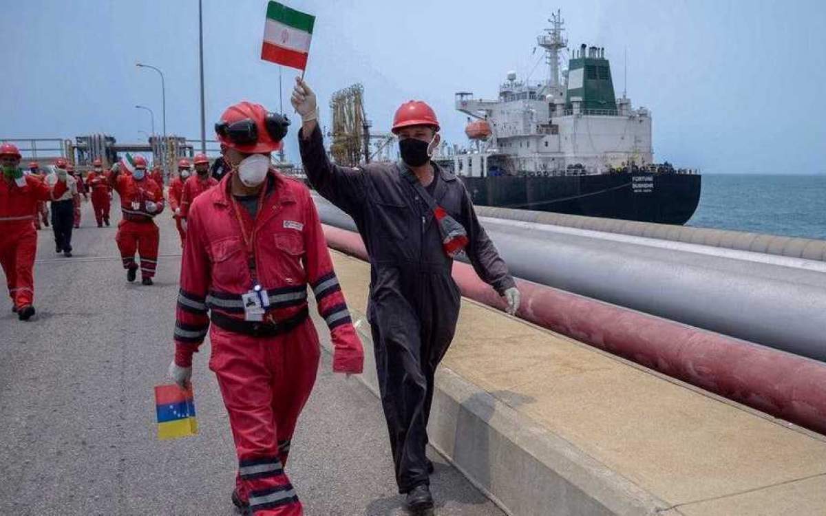 Oil workers carry Iranian and Venezuelan flags after an Iranian oil tanker arrived in the Venezuelan city of Puerto Cabello, home to the Latin American nation