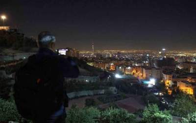 A man films a general view of Tehran after several explosions were heard in the Iranian capital on October 26, 2024.